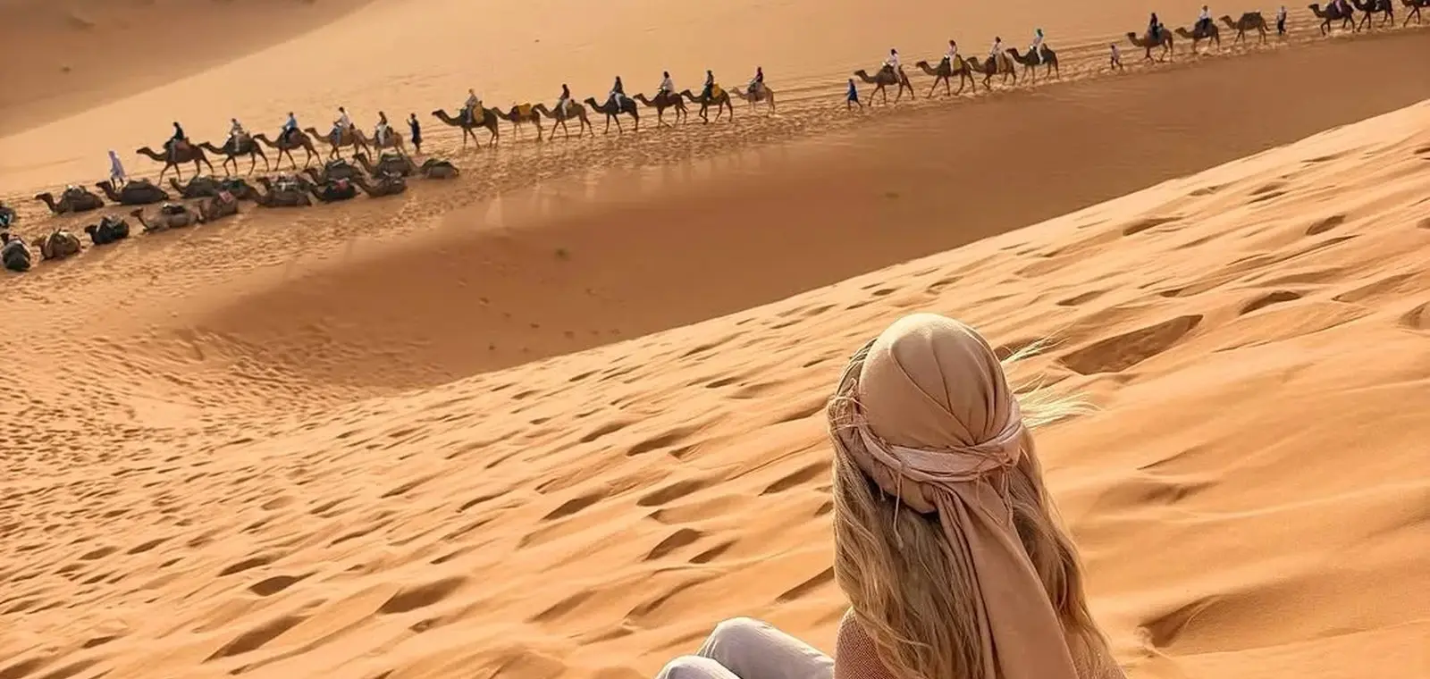 Caravana de camellos en el desierto del Sahara al atardecer